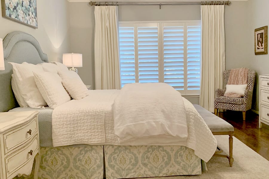 bedroom with white shutters and white drapery panels Friendswood TX