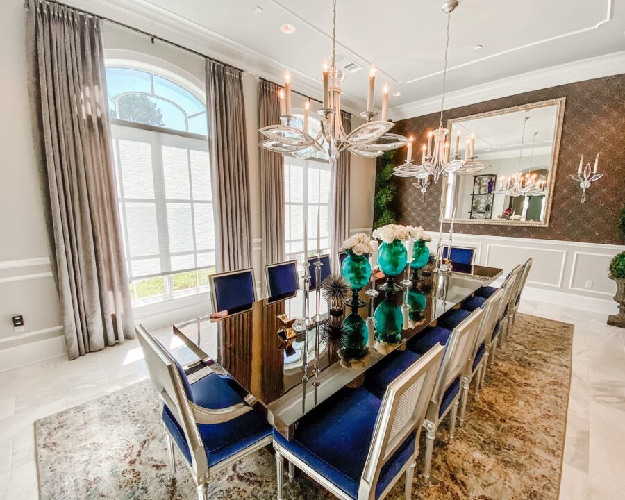 dining room with large arched windows featuring layered draperies and roller shades in Magnolia TX