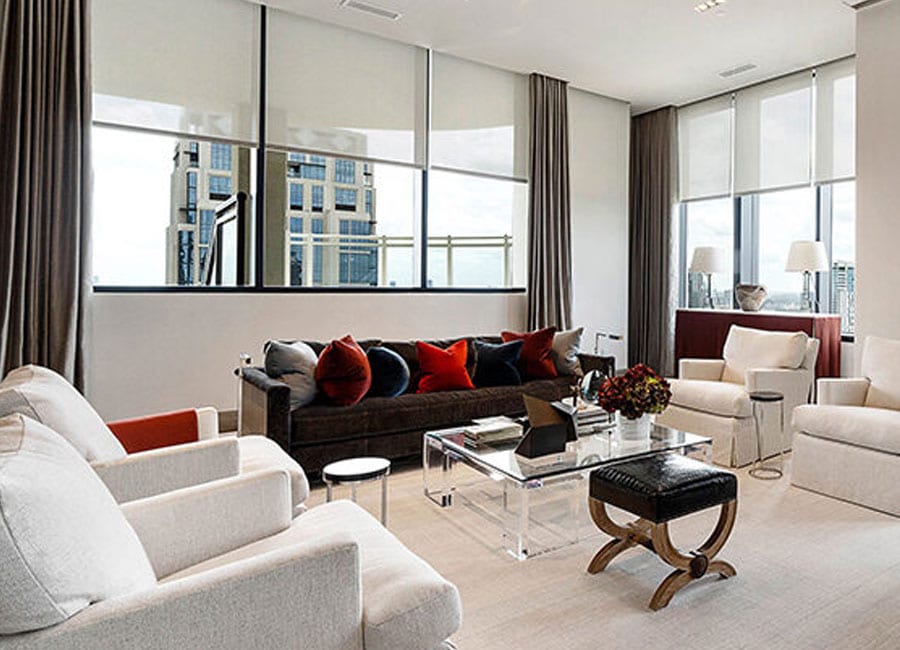 living room with layered window treatments draperies and roller shades in houston TX