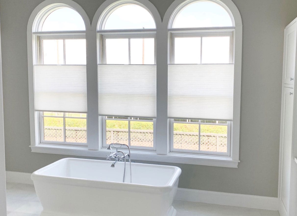 three arched windows in bathroom with white roller shades in Houston TX