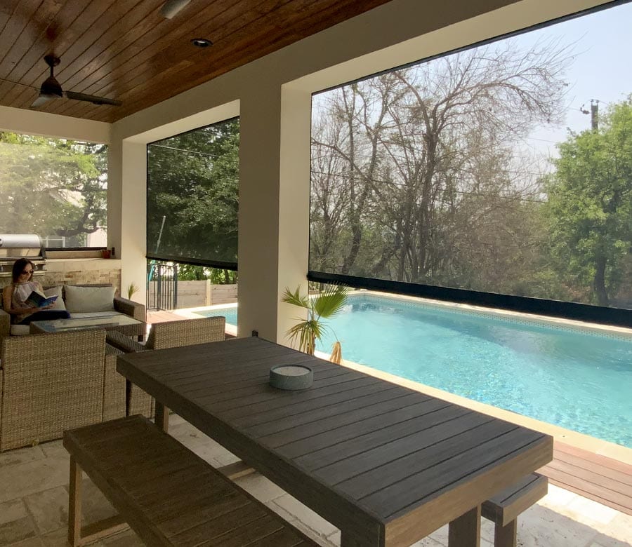 exterior patio shades half lowered by pool in Houston TX