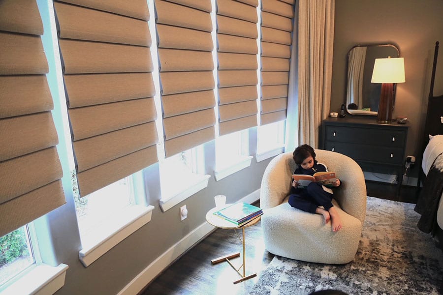 wall of windows in master bedroom covered with roman shades in Houston TX