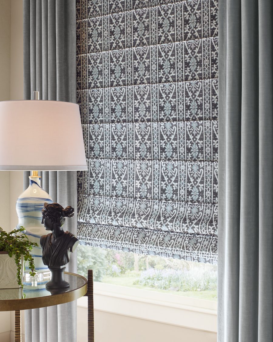 roman shades layered with custom drapery for light control and design