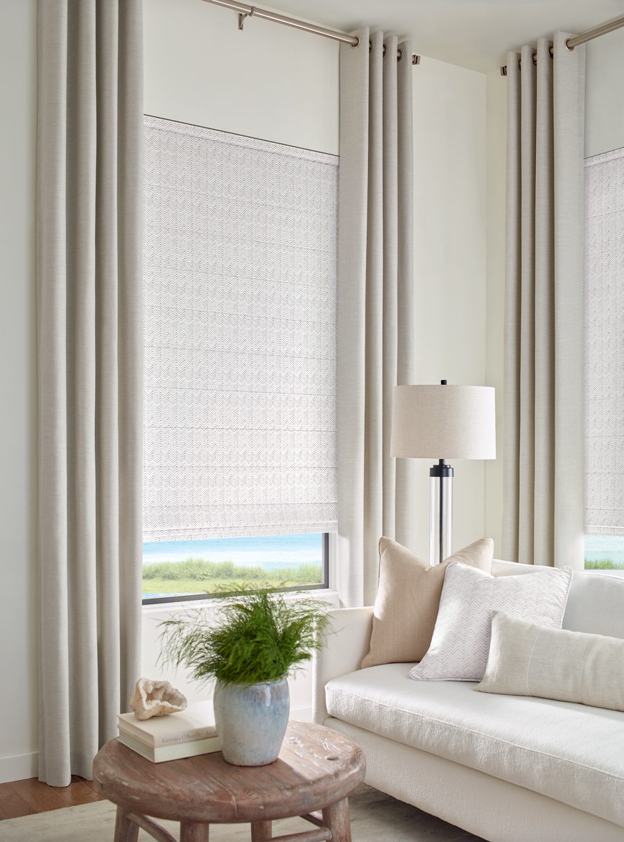 neutral drapery and roman shades on living room windows in Memorial TX