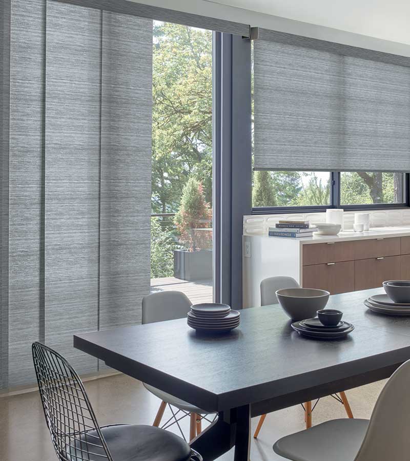 modern dining room space and large sliding glass door with gray window shade panels