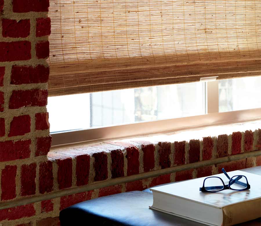 detail of custom woven shades in exposed brick apartment building Woodlands, TX