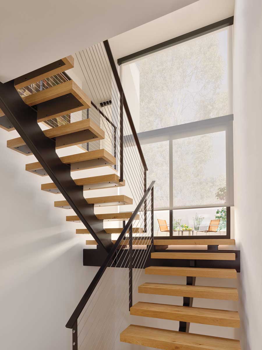staircase with white roller shades that are motorized
