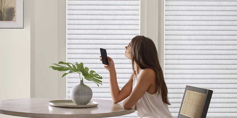 automatic white window coverings being operated with smart phone in kitchen