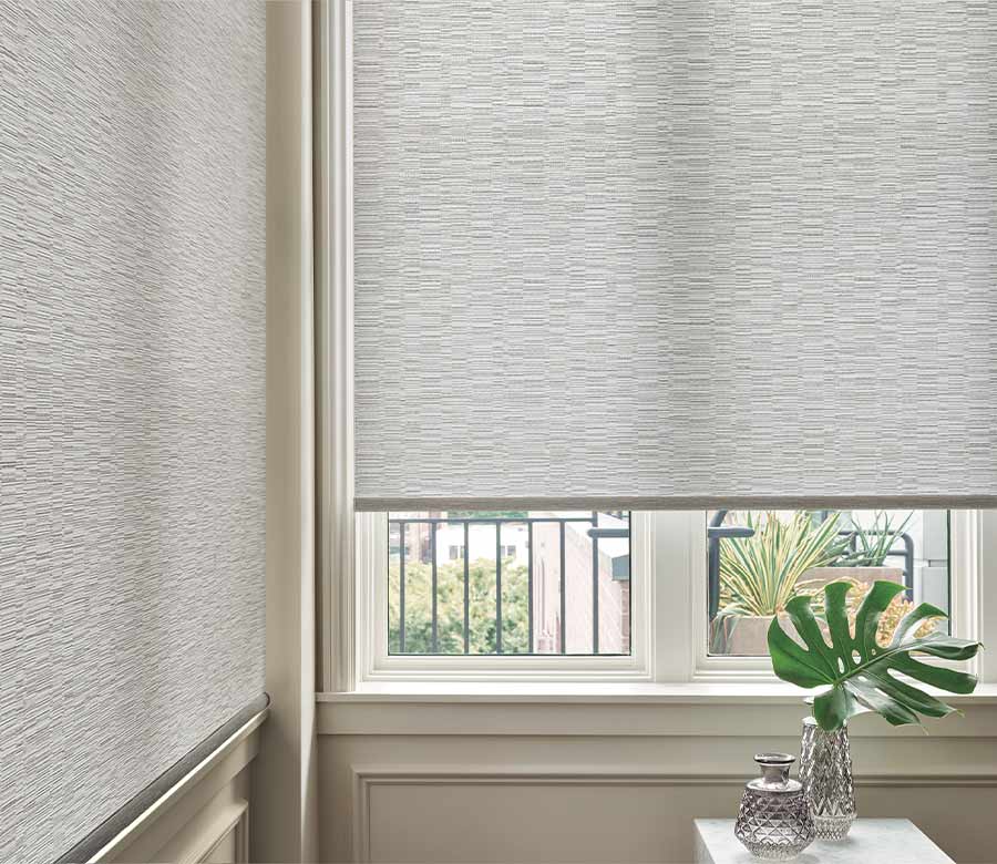 white designer roller shades in corner window
