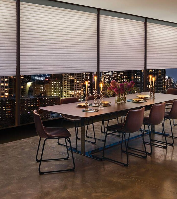 a highrise apartment dining room space with large window shades by hunter douglas