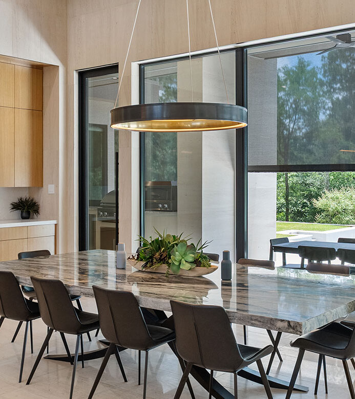 Black solar shades on floor-to-ceiling dining room windows in a Galveston home