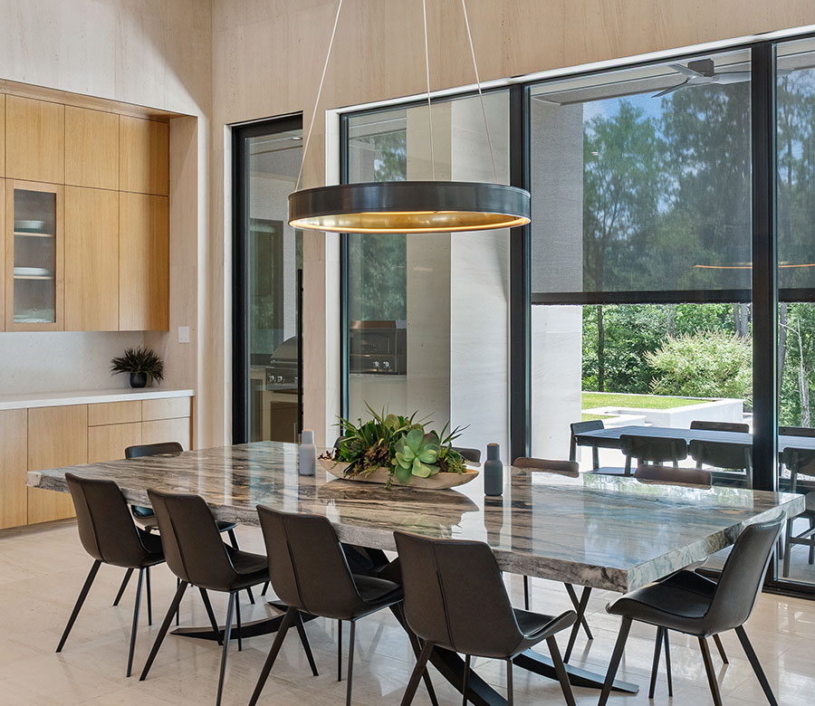 Black solar shades on floor-to-ceiling dining room windows in a Galveston home