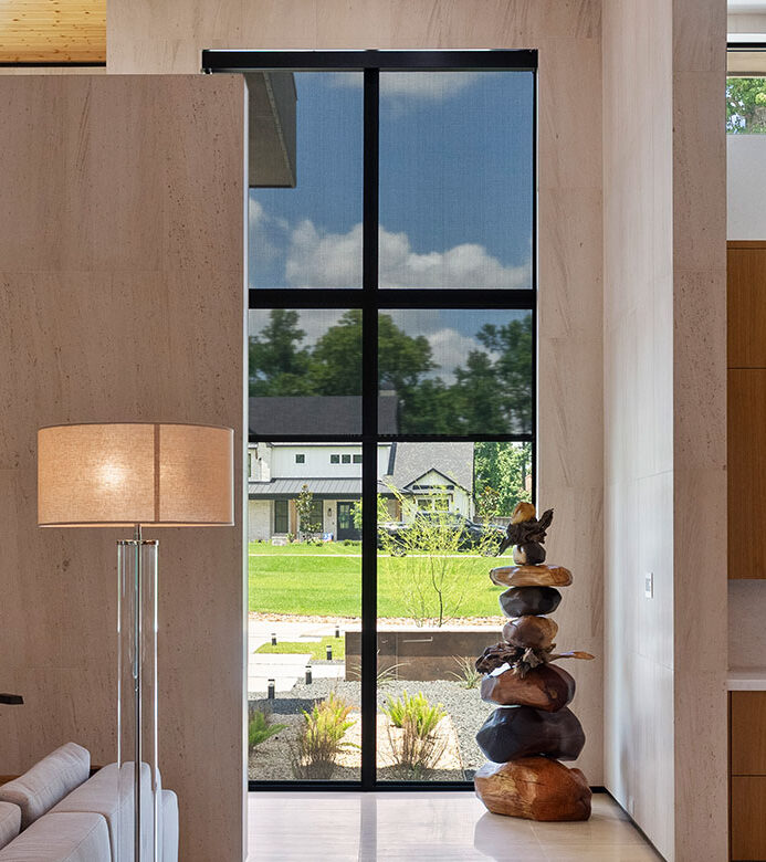 Black solar shades on floor-to-ceiling windows in a Galveston home
