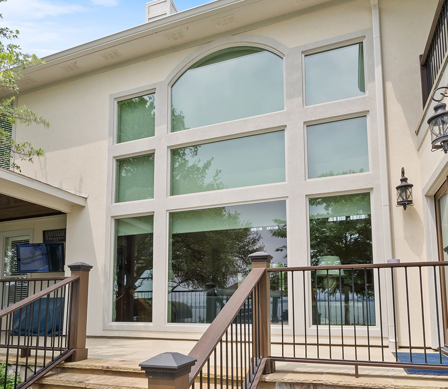 Light-filtering roller shades visible through floor-to-ceiling windows of a Lake Conroe home