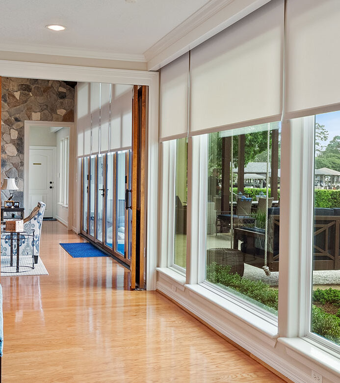 Designer Roller Shades coordinating across windows in an open-concept Lake Conroe home