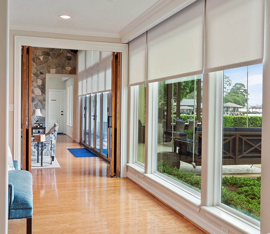 Designer Roller Shades coordinating across windows in an open-concept Lake Conroe home