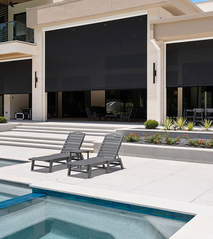 Black motorized patio shades beside the pool at a Galveston home