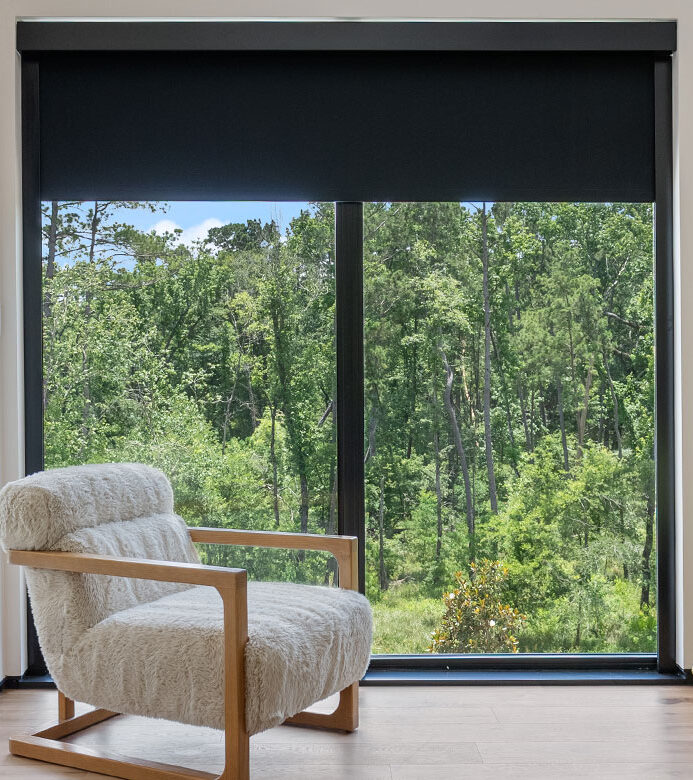 Room-darkening roller shade on a bedroom window in a Galveston home