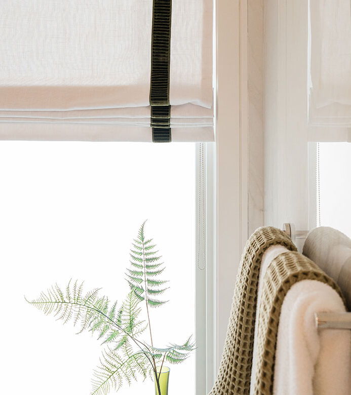 close up of Green edge banding detail on neutral fabric Roman shades