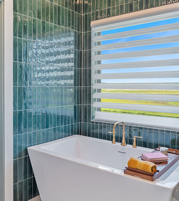 White motorized Pirouette® shade on a bathroom window over the tub