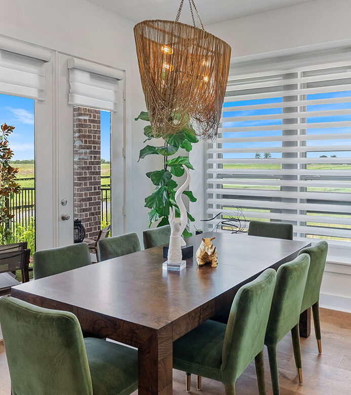 White Pirouette® shades filtering natural light through large dining room windows