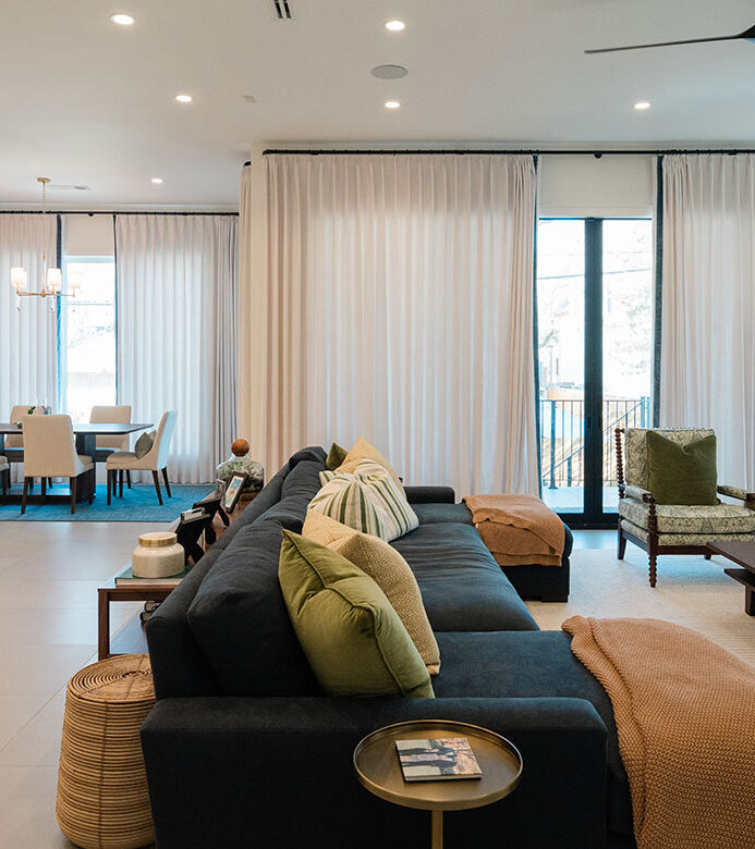 Custom drapery with blue edge banding on large picture windows and over sliding doors in open floor plan