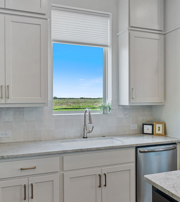 White Duette® Honeycomb Shade filtering natural light over a kitchen sink